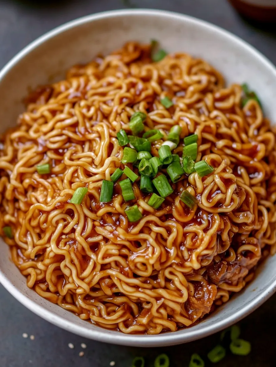 A bowl of noodles with green onions.