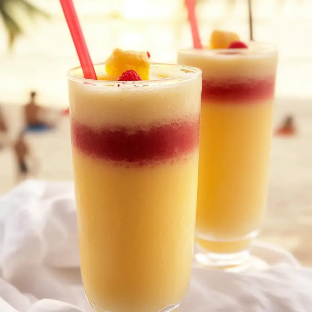 Two glasses filled with orange drink and straws.