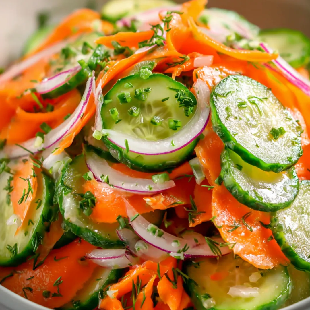 A bowl of vegetables including carrots, cucumbers, and onions.