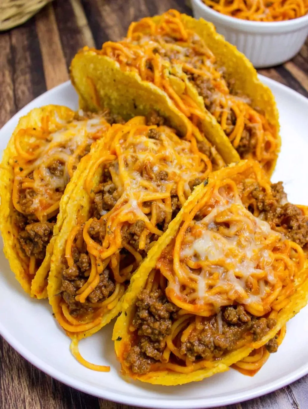 A plate of cheese and meat filled tacos.