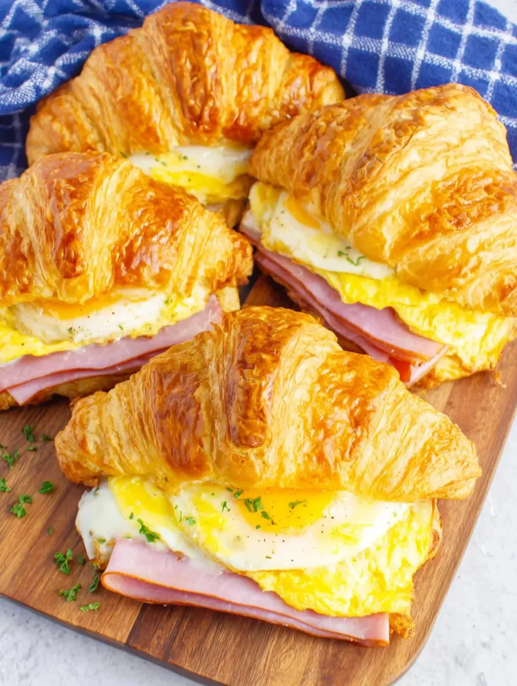 A plate of croissants with eggs and ham.