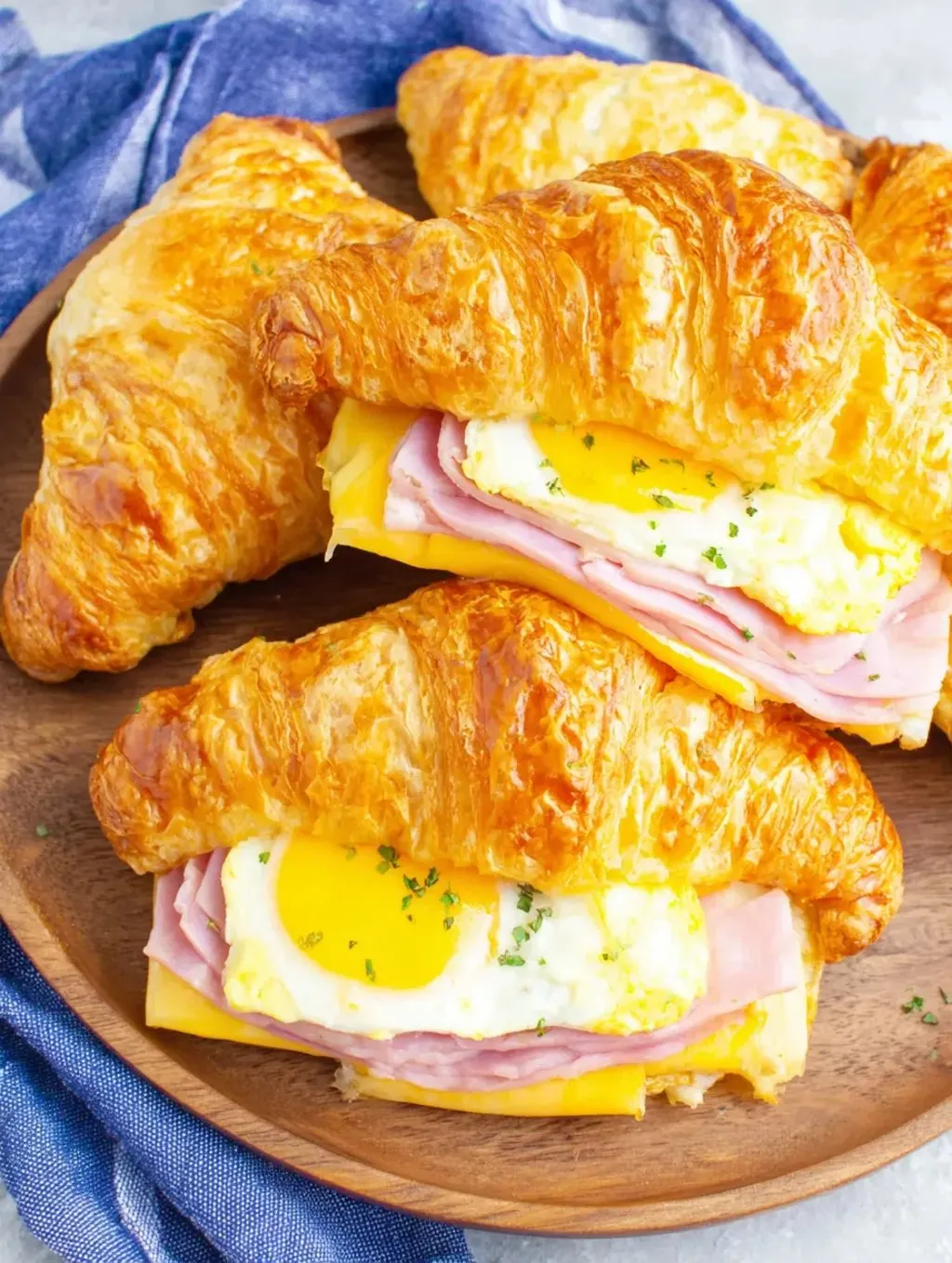 A plate of croissants with eggs and ham.
