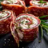 A plate of meat rolls with cheese.