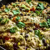 A pan of rice with chicken, beans, and tomatoes.