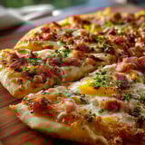 A pizza with ham and cheese on top.