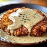 A plate of food with gravy on it.