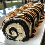 A plate of food with a cake roll and a chocolate roll.