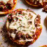 A close up of a pizza with cheese and meat on it.