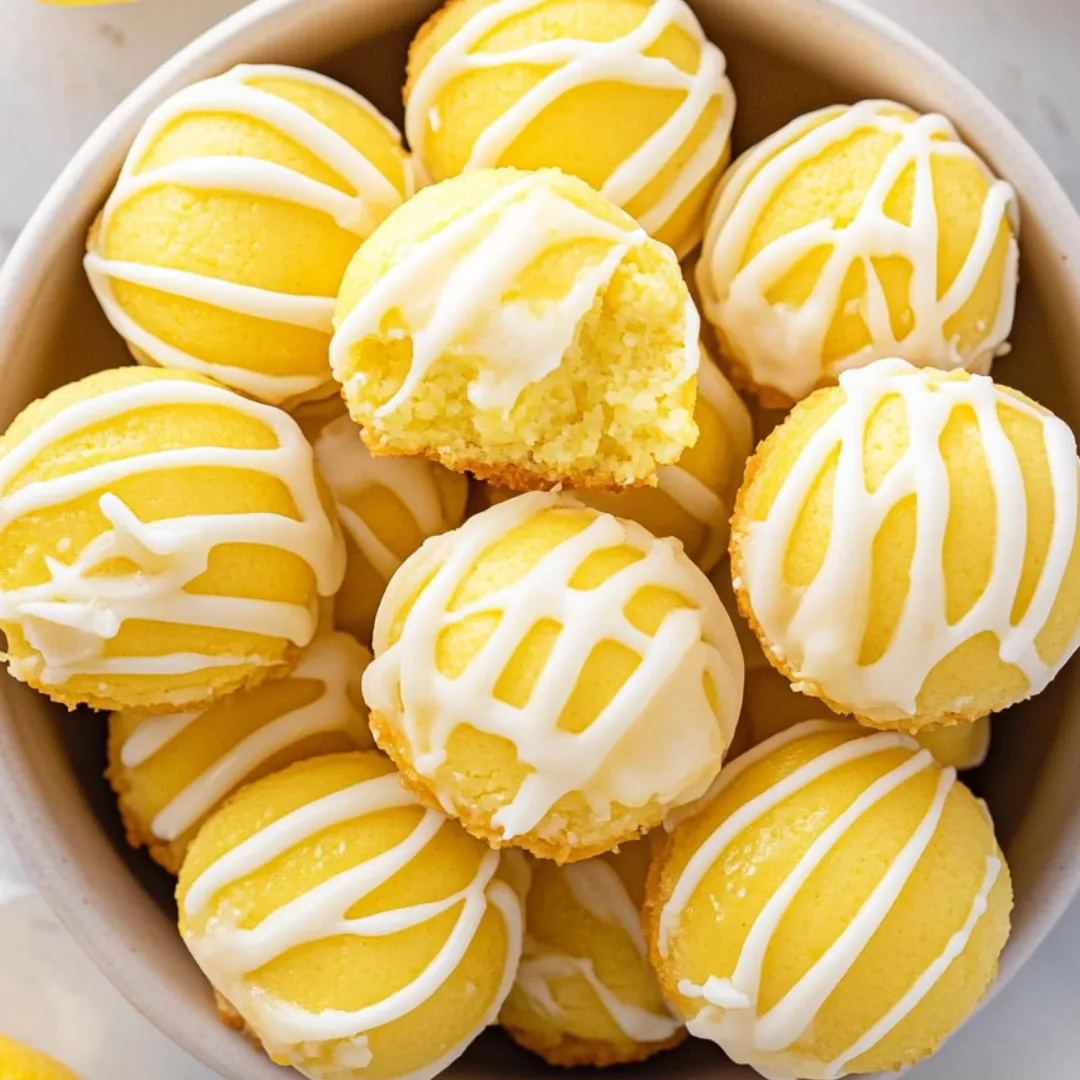 A bowl full of yellow cake with white icing.