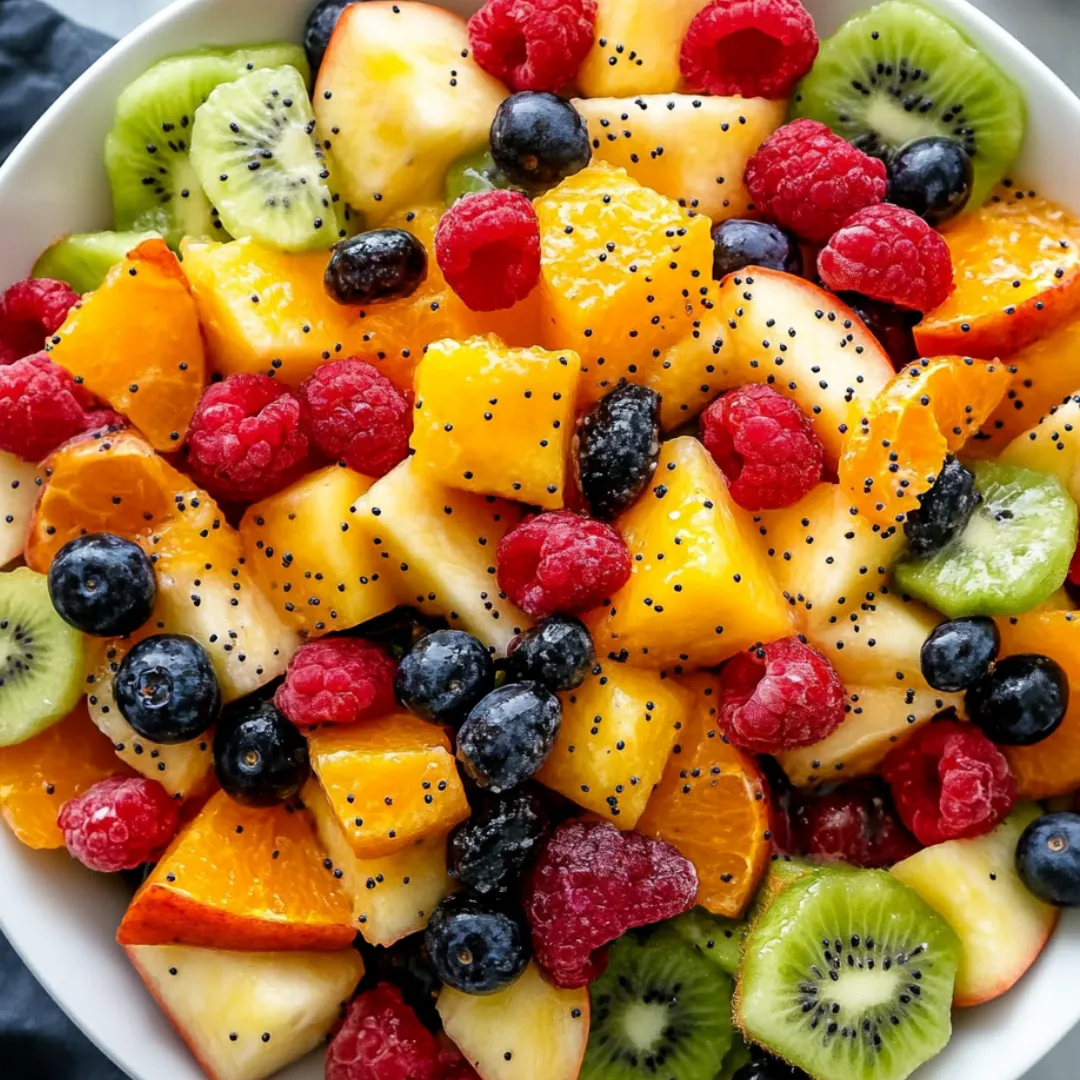 A bowl of fruit with a variety of fruits including kiwi, blueberries, raspberries, and oranges.