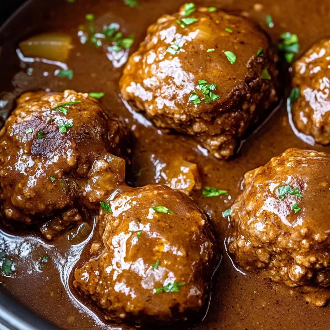 A bowl of meatballs in a brown sauce.