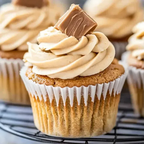A cupcake with a peanut butter frosting and a chocolate topping.