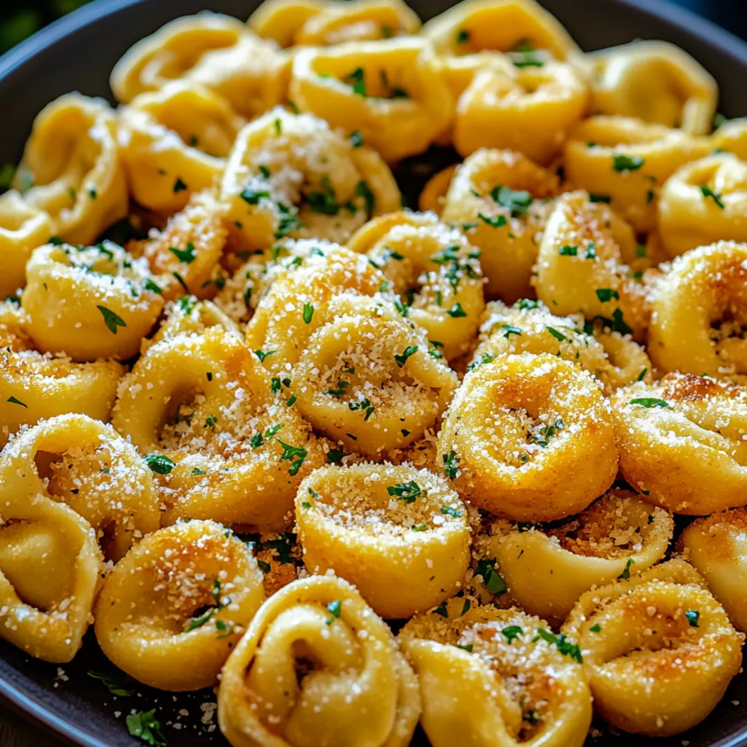 A bowl of pasta with cheese and herbs.