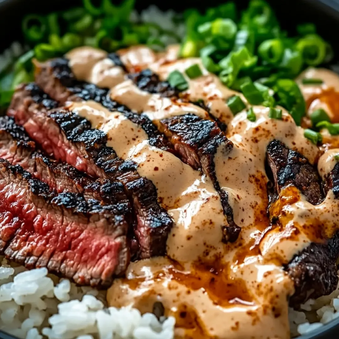 A bowl of rice with meat and sauce.