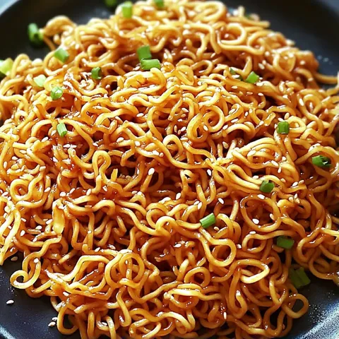 A bowl of noodles with green onions.