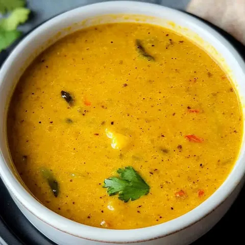 A bowl of soup with a green garnish.