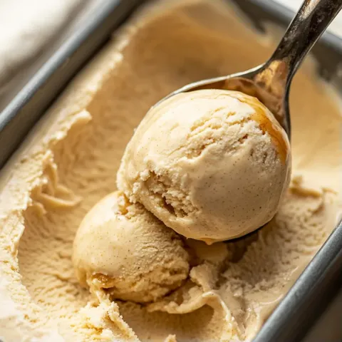A spoon in a bowl of ice cream.