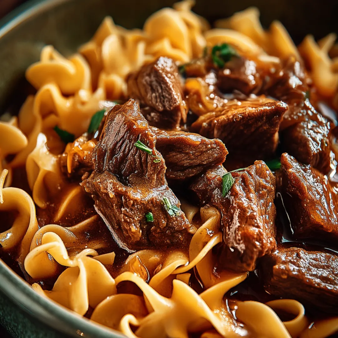 A bowl of noodles with meat and vegetables.