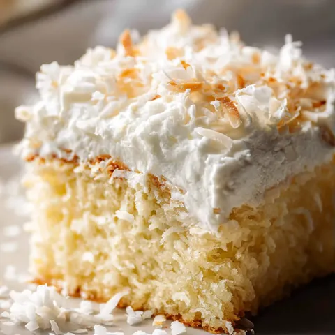 A slice of cake with coconut on top.