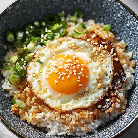 A bowl of rice with an egg on top.