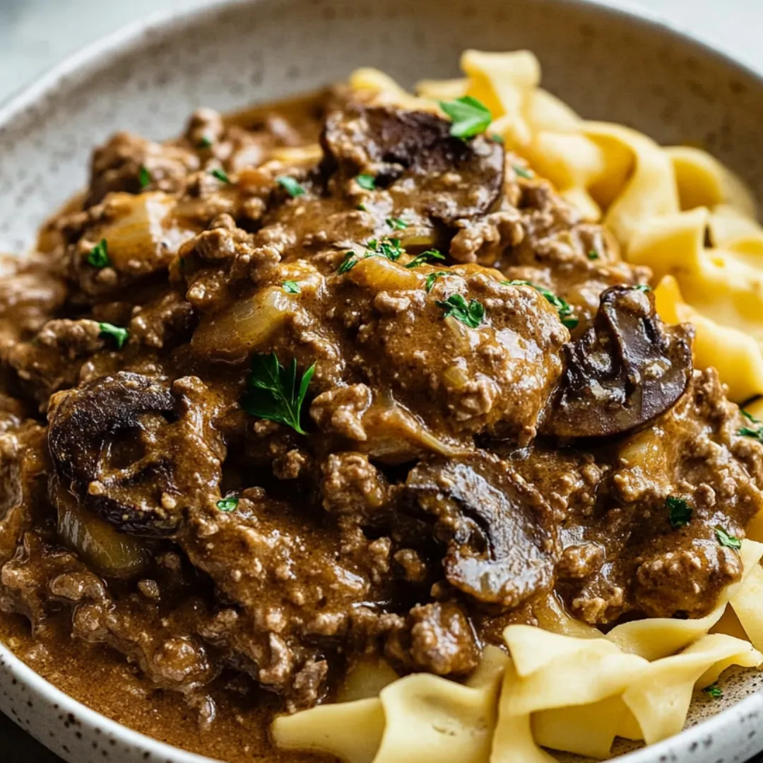 A bowl of food with pasta and meat.