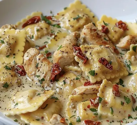 A plate of pasta with chicken and red peppers.