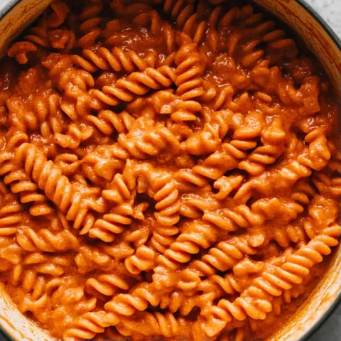 A bowl of pasta with sauce.
