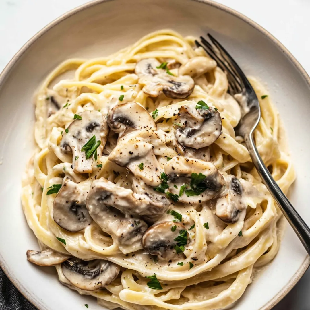 A plate of pasta with mushrooms and herbs.