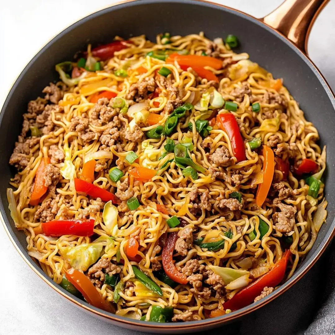 Bowl loaded with noodles, meat, and bright veggies.
