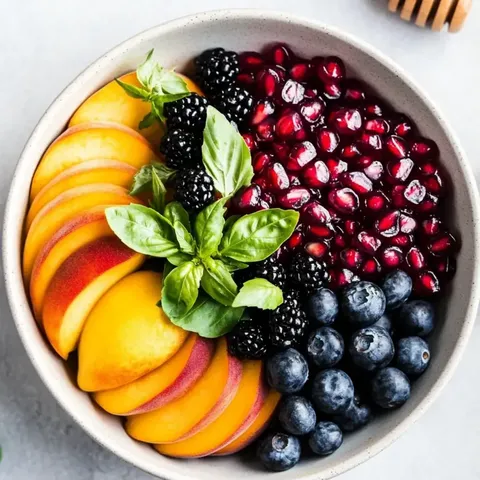 Fruity bowl loaded with juicy peaches, blueberries, blackberries, and raspberries.