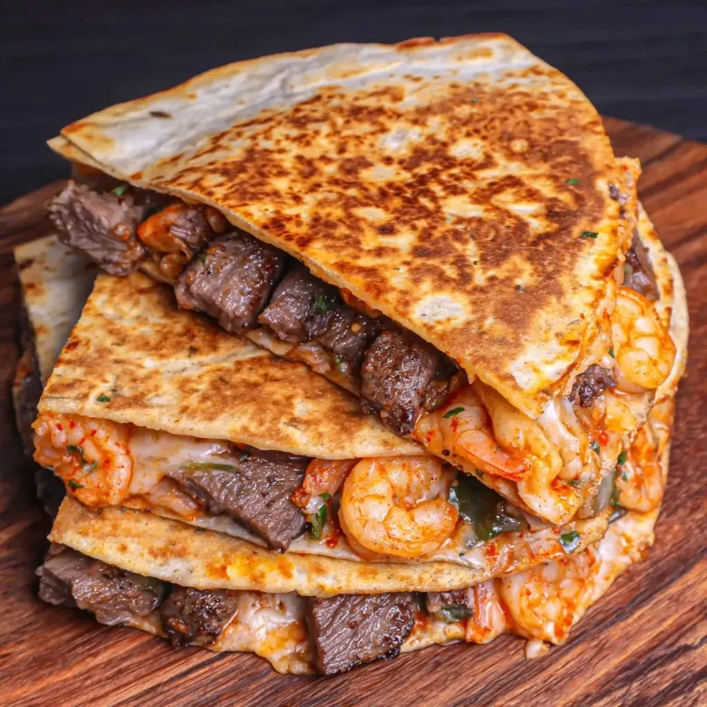 A stack of shrimp and beef tacos.