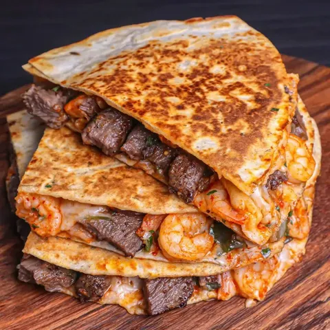 A stack of shrimp and beef tacos.