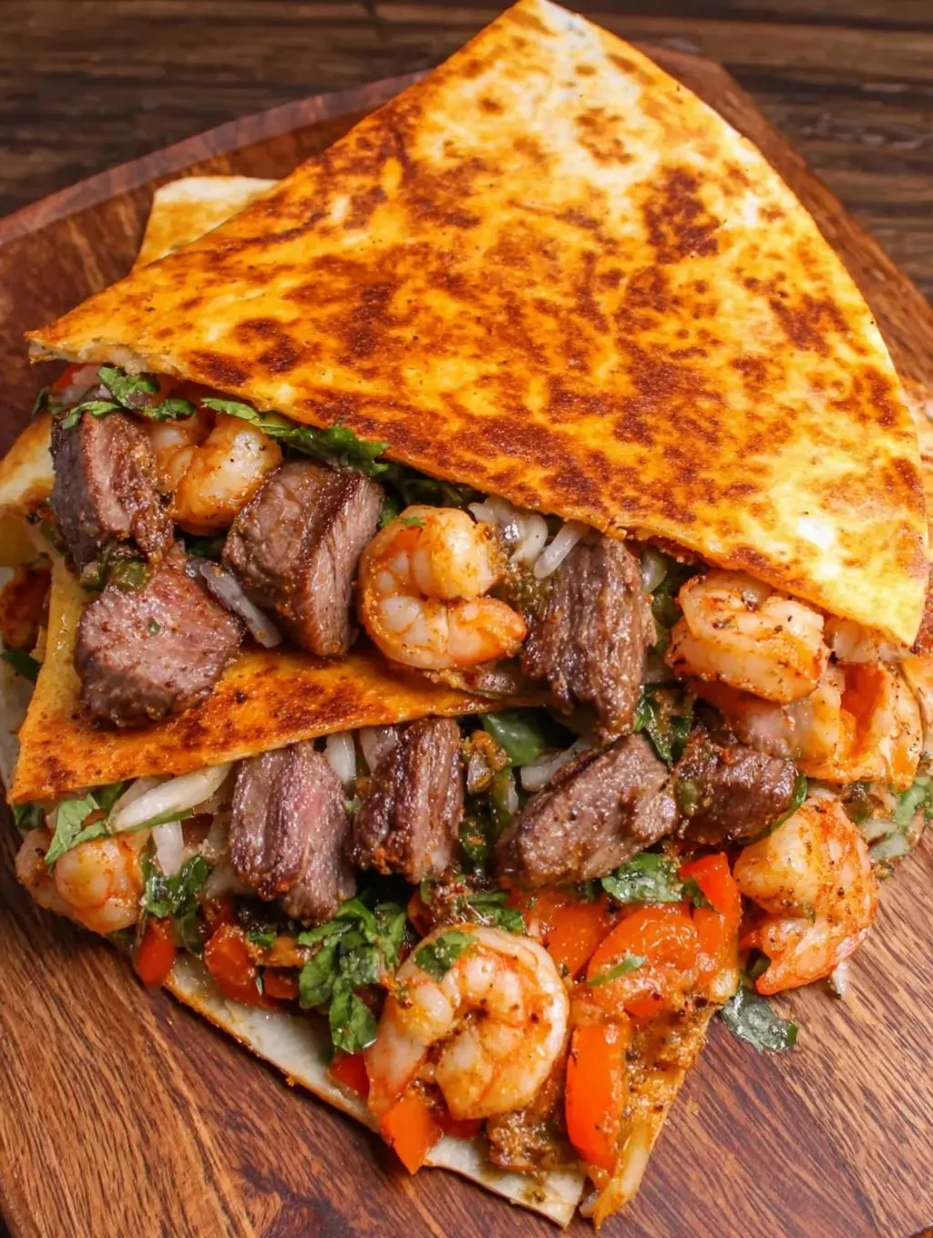 A burrito with shrimp, meat, and lettuce.