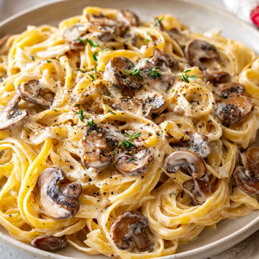 A plate of pasta with mushrooms and cheese.