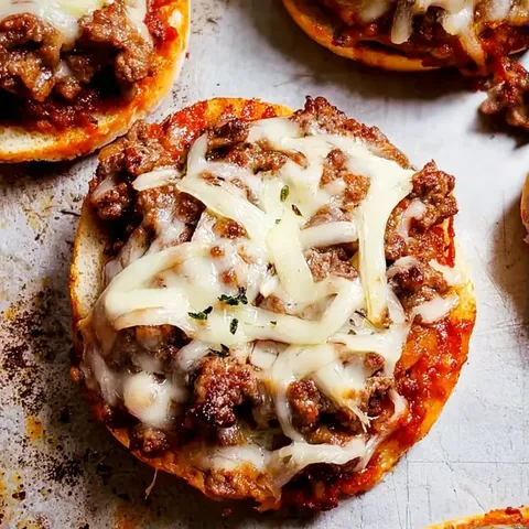A close up of a pizza with cheese and meat on it.