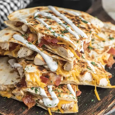 A stack of chicken sandwiches with white sauce.