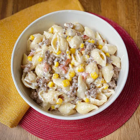 A bowl of pasta with meat and corn.