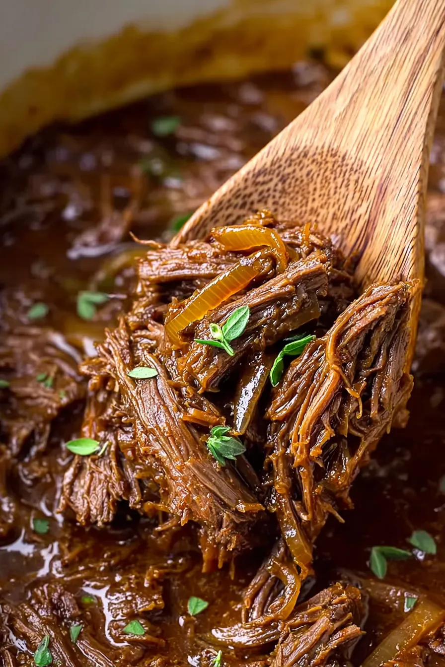 A wooden spoon in a bowl of beef stew.