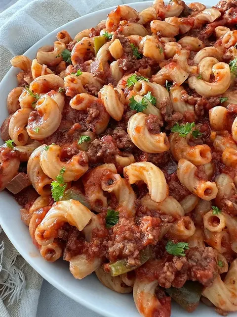 A plate of pasta with meat and sauce.
