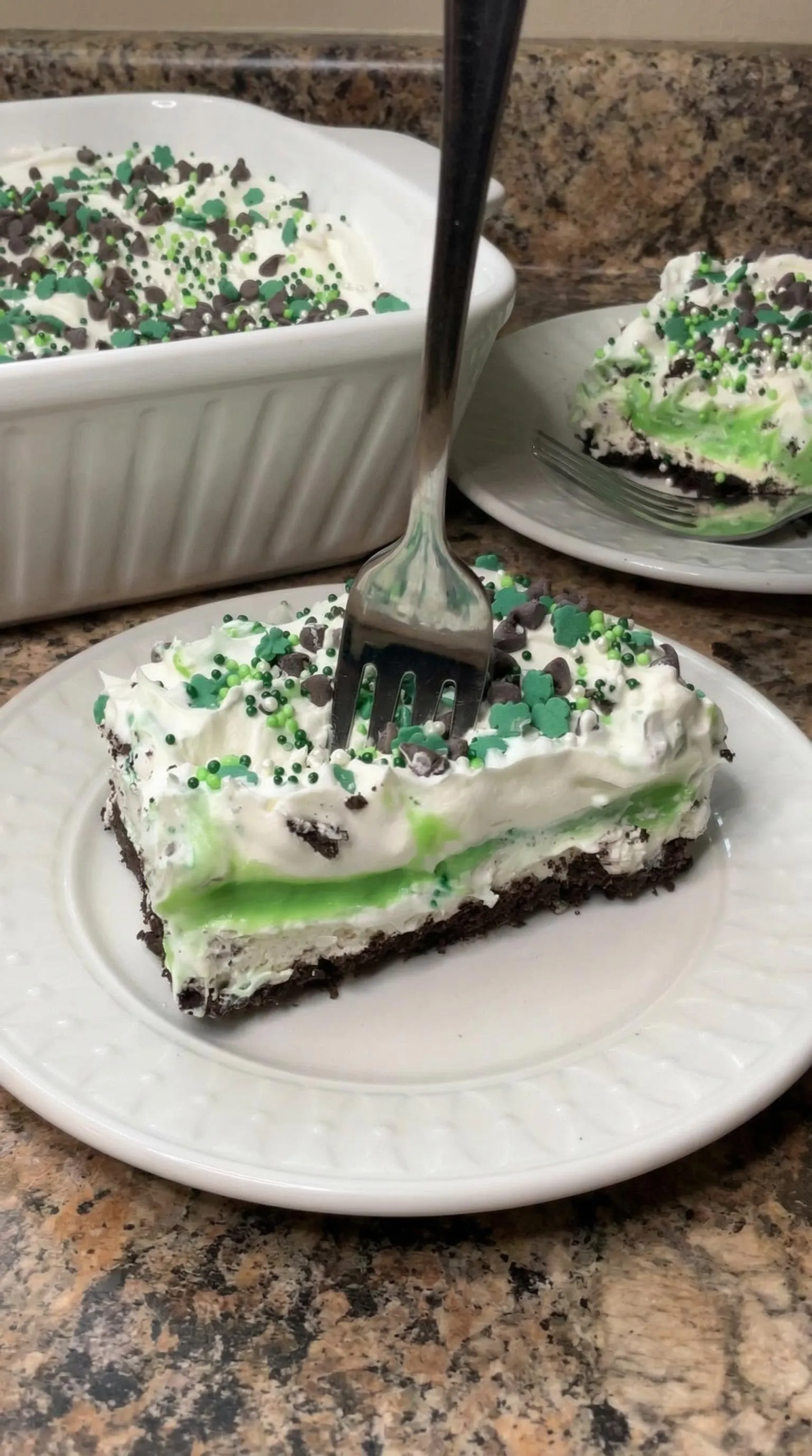 A piece of cake with green and white frosting.