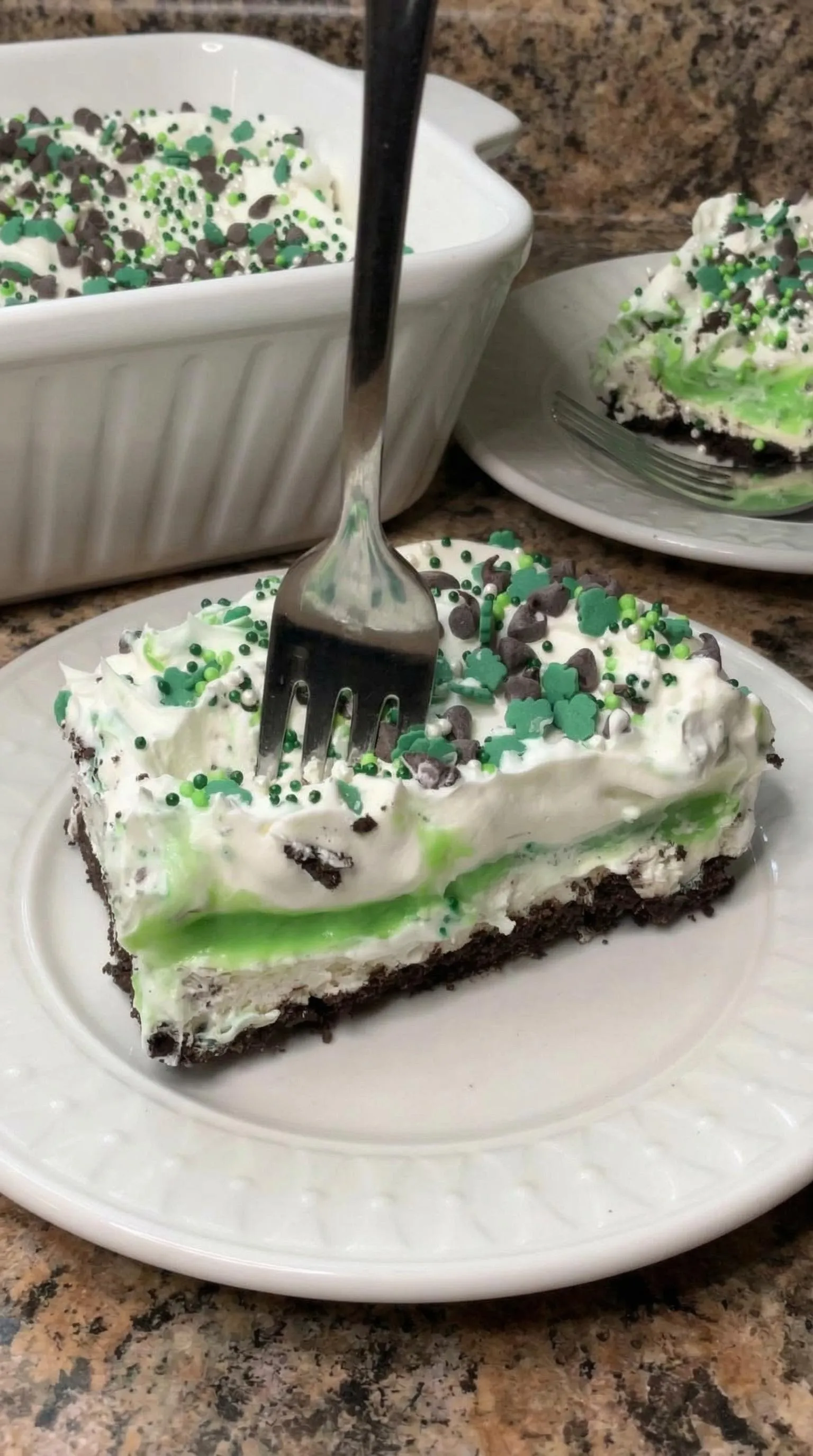 A slice of cake with green and white frosting.