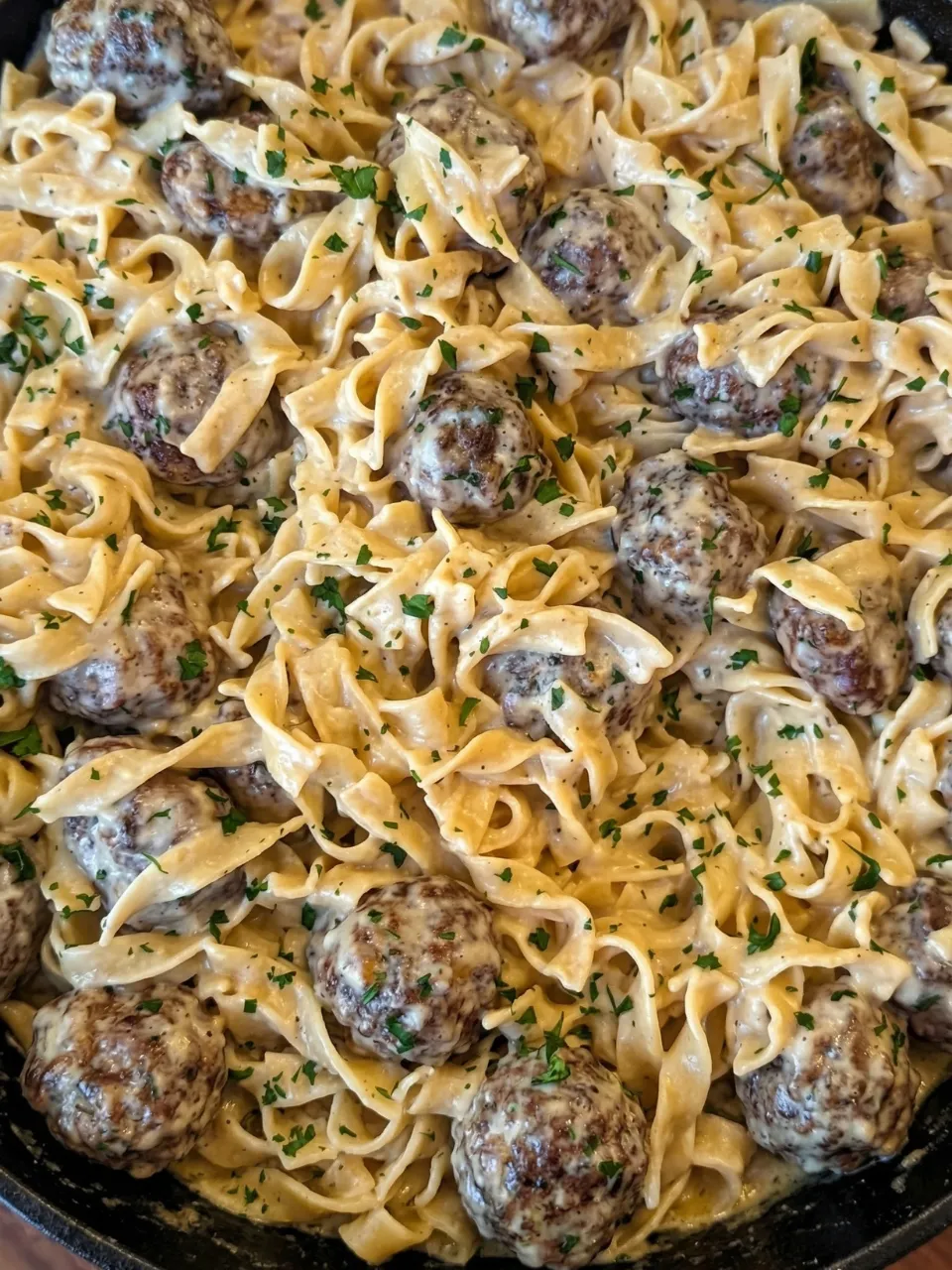 A plate of pasta with meatballs and noodles.