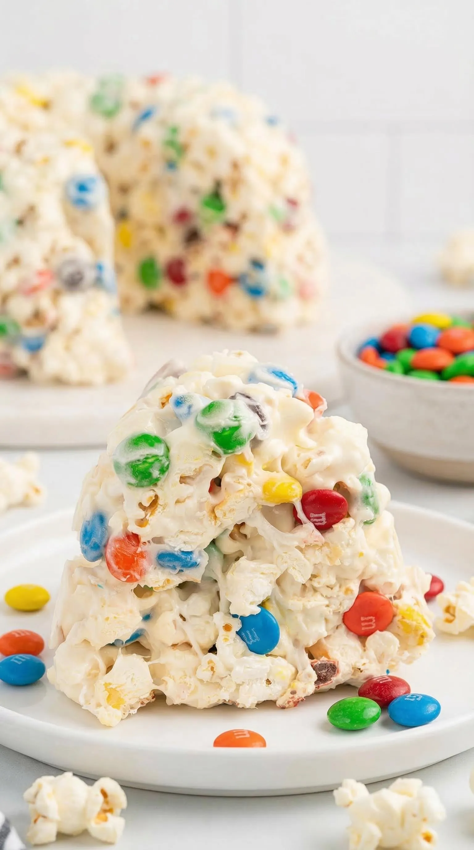 A stack of marshmallows with M&amp;M's on top.