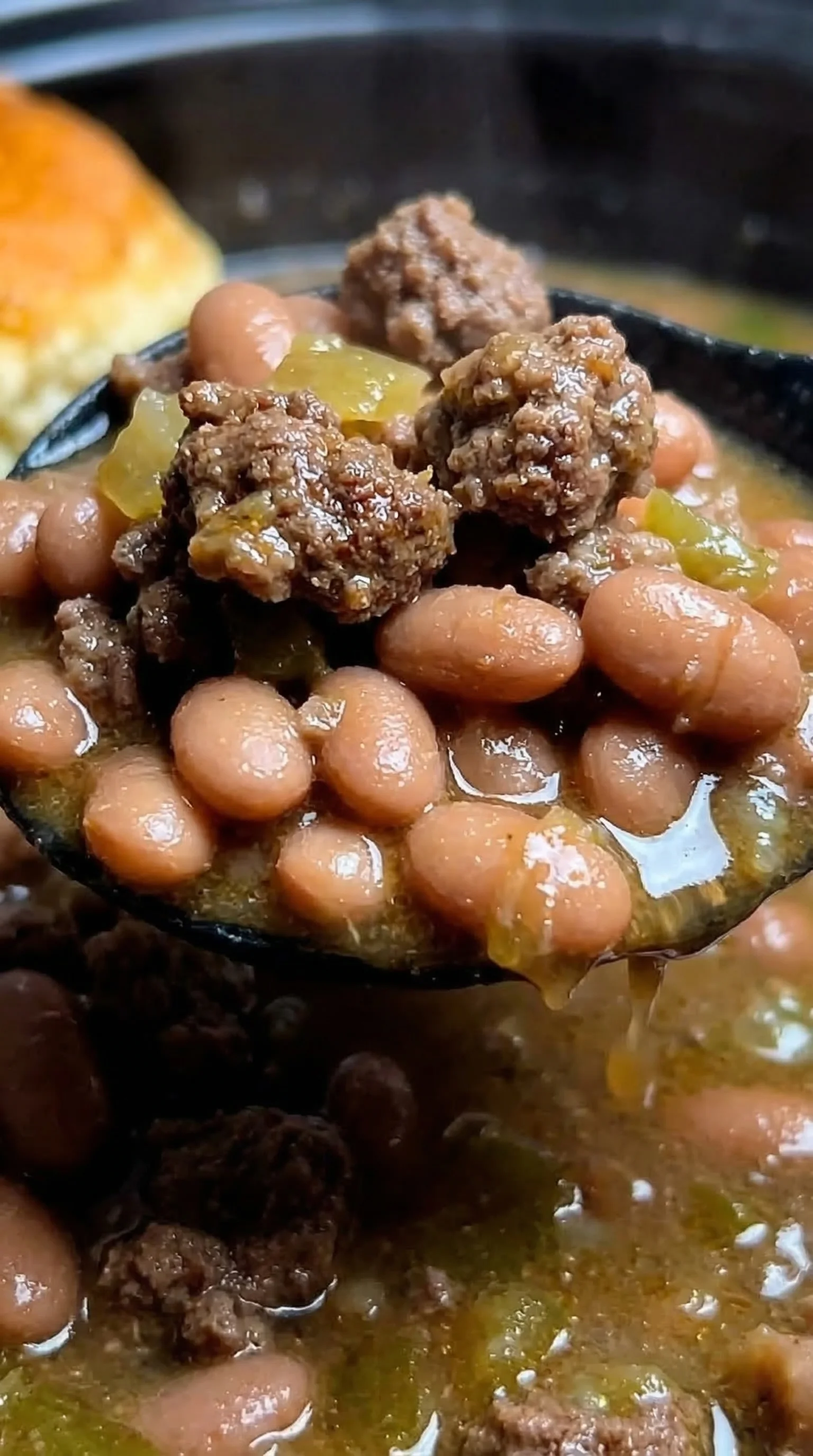 A bowl of beans with meat and peppers.