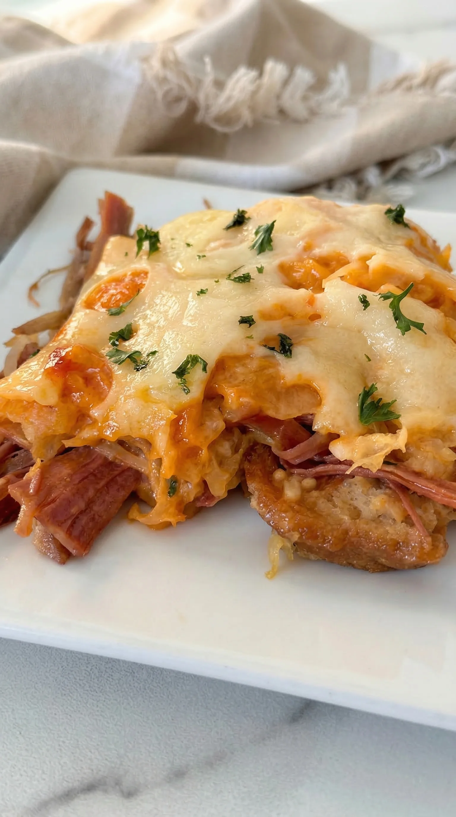 A slice of meat with cheese on top.