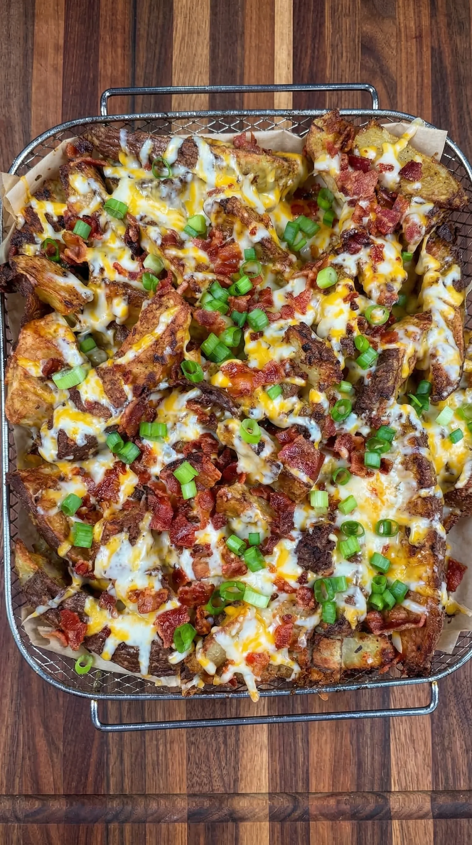 A close up of a delicious bacon and cheese covered potato.