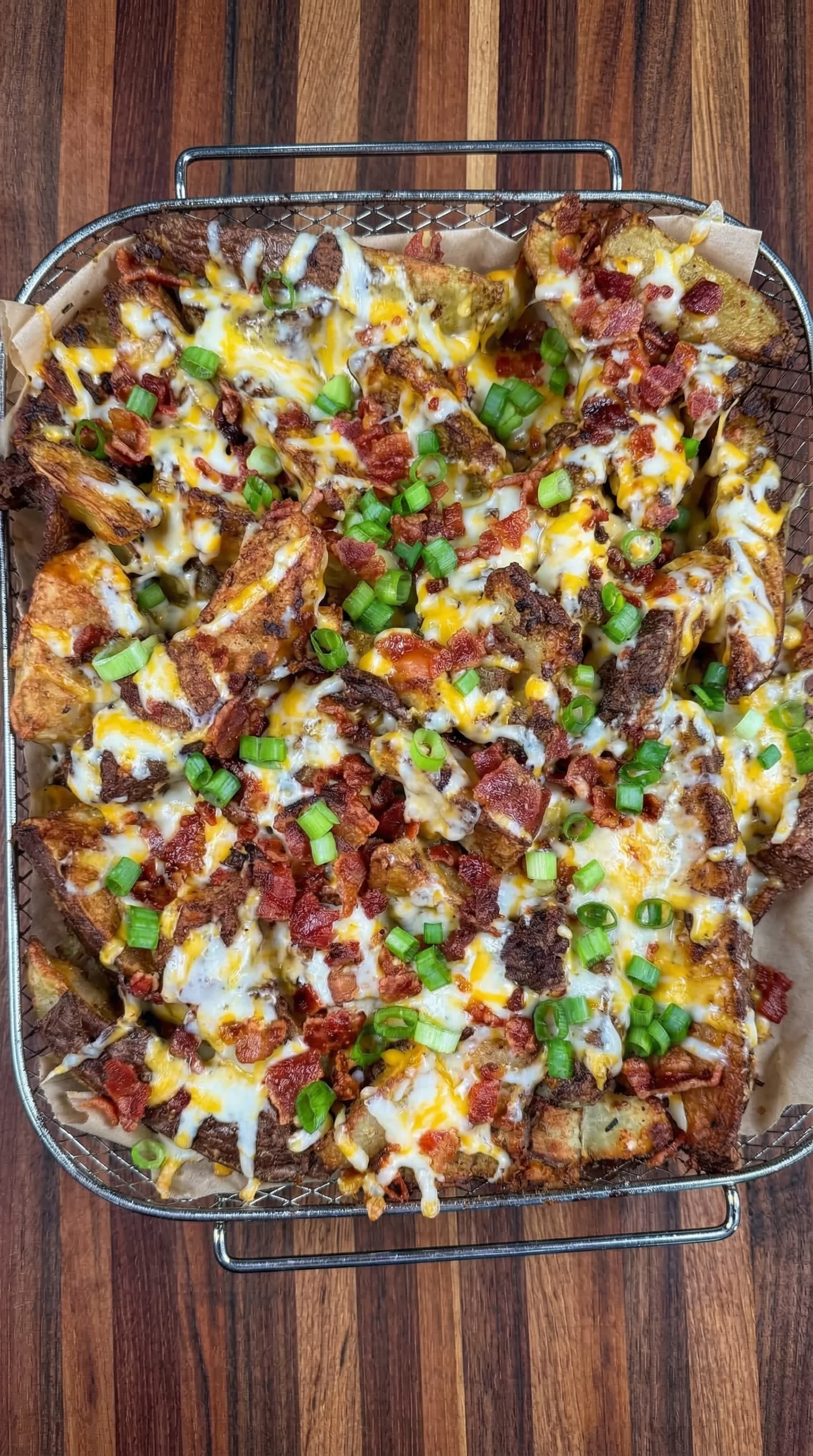 A plate of bacon and cheese covered potatoes.