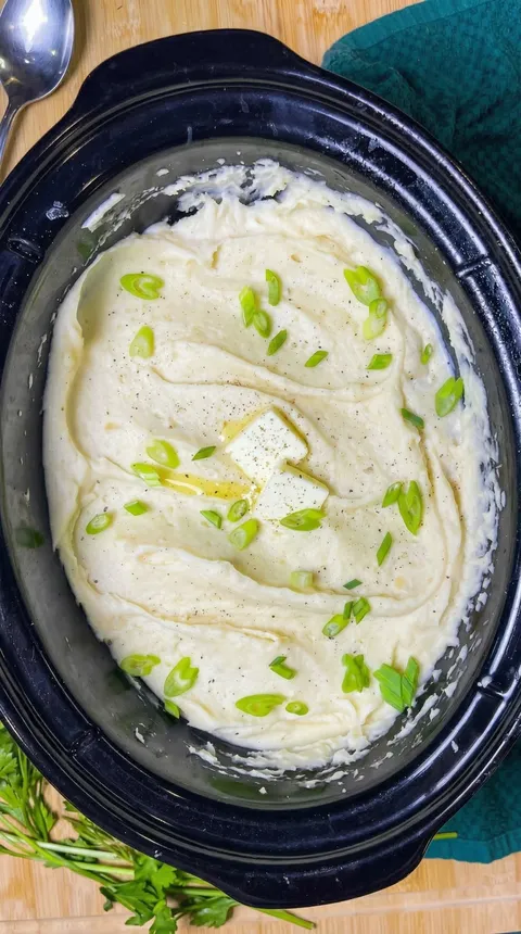 A bowl of mashed potatoes with green onions.