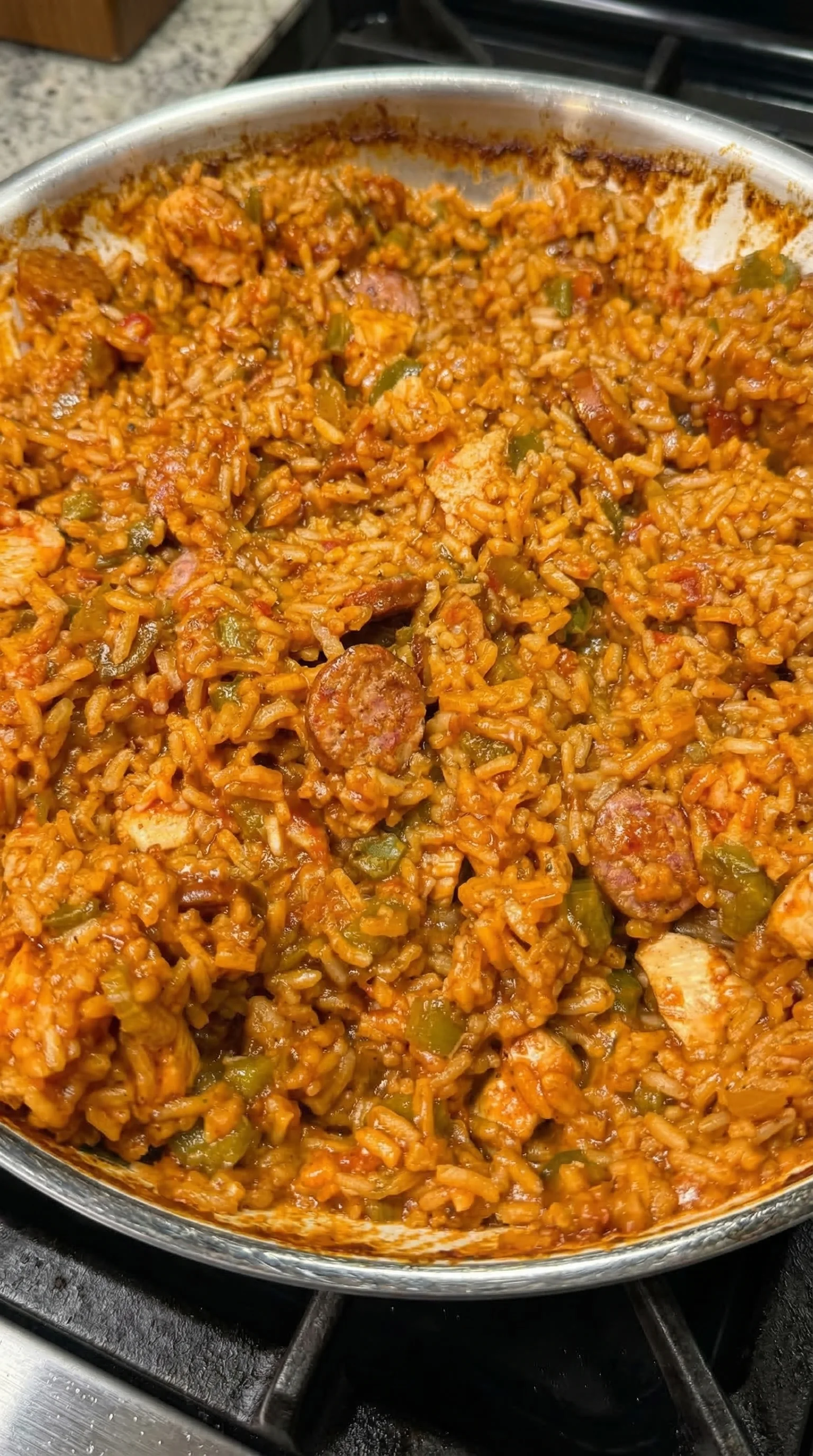 A bowl of rice with sausage and peppers.