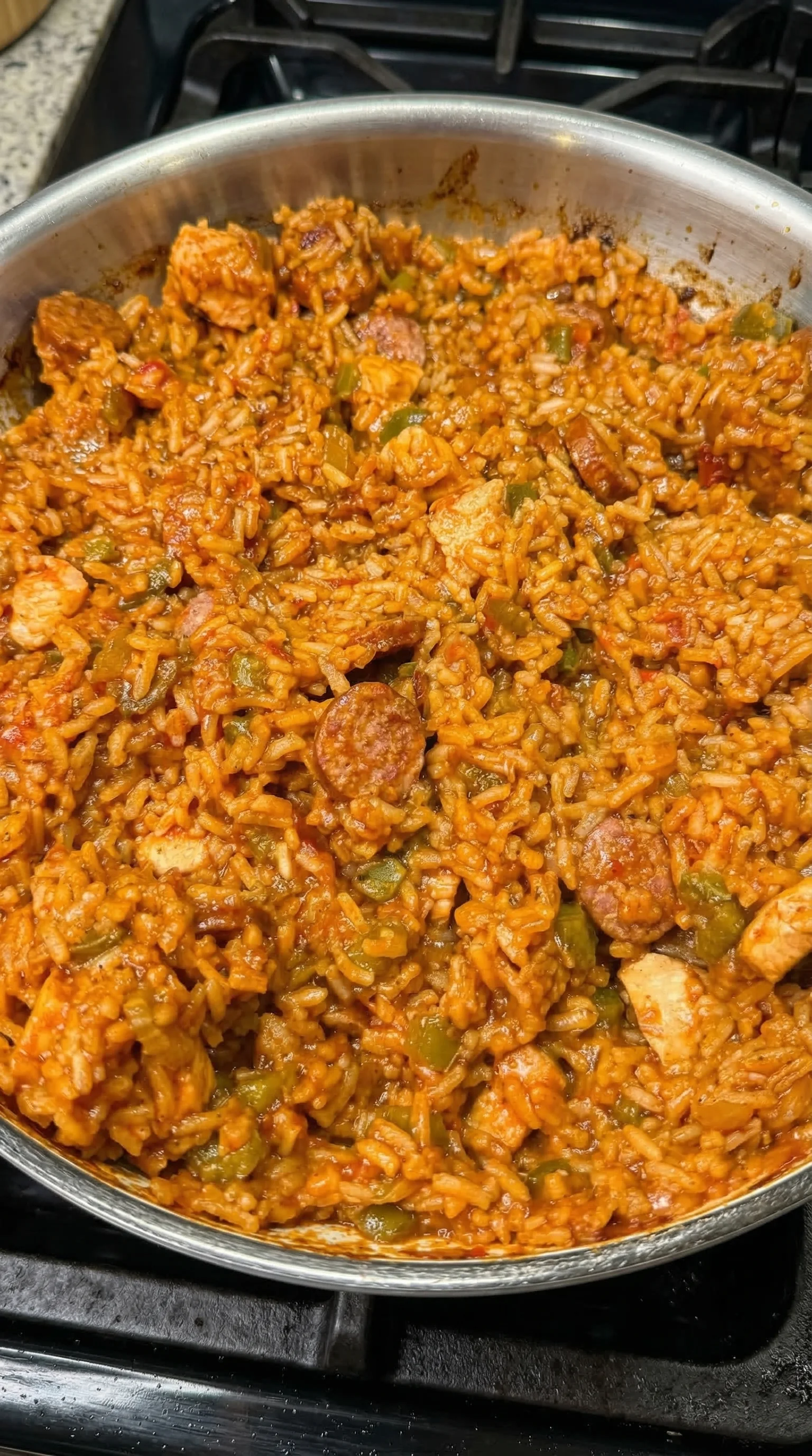 A bowl of rice with sausage and peppers.